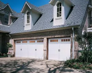 White garage doors on brick house
