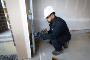Worker installing equipment in construction site.