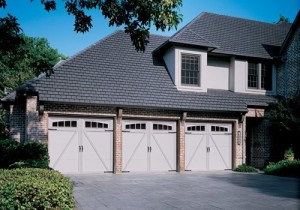 Three white garage doors in a large home in Erlanger, Kentucky.