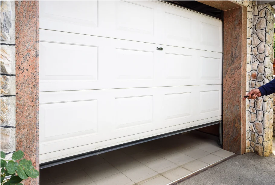 Exterior of white garage door stuck partially open