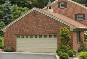 Vinyl-clad two-car garage door on a large brick home.